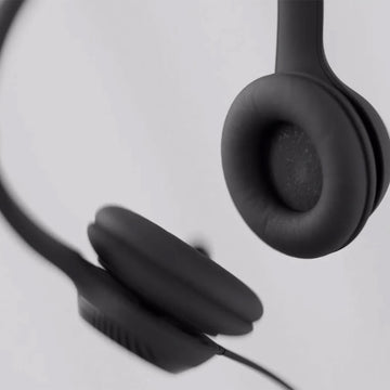 Macro shot of the black, padded earcups of the Logitech H390 Headset, highlighting the soft texture and comfortable design for extended wear.